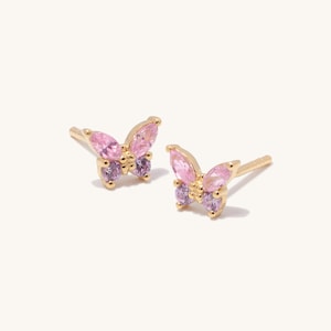 Può includere: Un paio di orecchini a farfalla in oro con pietre preziose rosa e viola.
