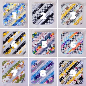 May include: Nine different fabric squares with a diagonal pattern. Each square has a number from 1 to 9 printed on it.