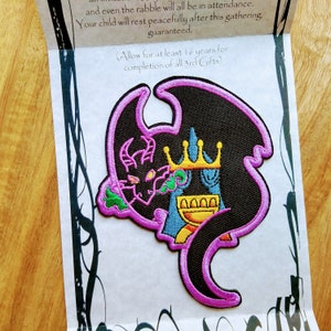 May include: An embroidered iron-on patch featuring a purple dragon with a black body and yellow crown. The dragon is holding a blue and yellow goblet with a gold rim. The text "Allow for at least 16 years for completion of all 3rd Gifts" is printed on the white background.