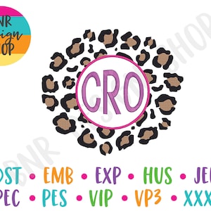 May include: A monogram design with the letters "CRO" in a purple font on a white circle. The circle is surrounded by a brown and black leopard print pattern.