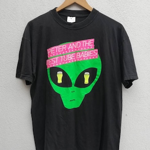 May include: Black t-shirt with a green alien graphic and the text "Peter and the Test Tube Babies" in pink.
