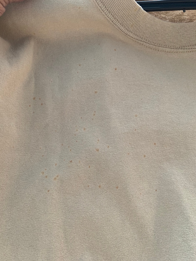 Puede incluir: Primer plano de una tela beige claro con varias manchas marrones peque&ntilde;as.