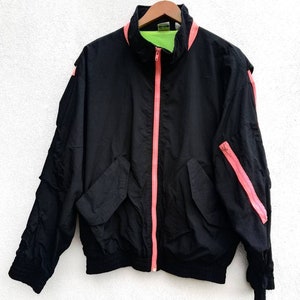 May include: A black jacket with a pink zipper and pink accents on the sleeves. The jacket has a green lining.