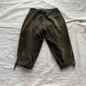 K&ouml;nnte beinhalten: Dunkel olivgr&uuml;ne Reithose mit verst&auml;rktem Sitz. Die Hose hat eine hohe Taille und ist am Unterschenkel gek&uuml;rzt. Sie verf&uuml;gt &uuml;ber verstellbare Schnallen an den Manschetten.