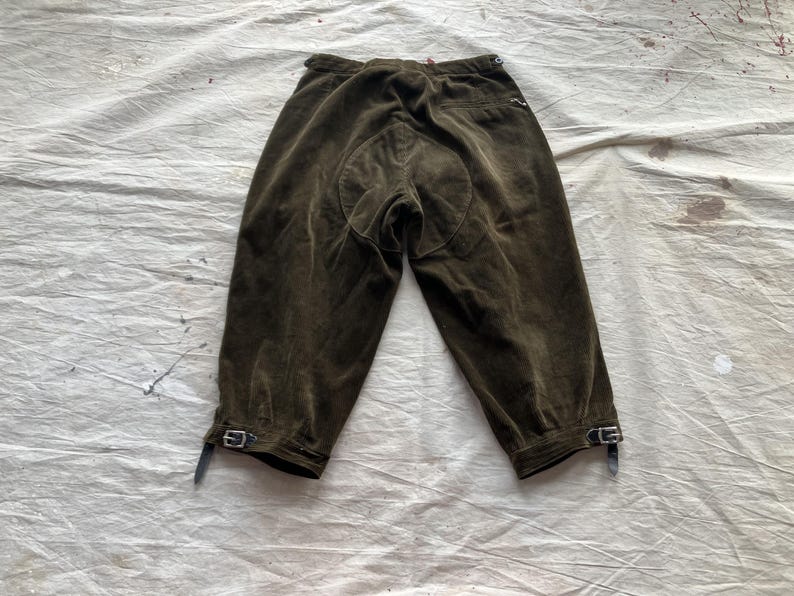 K&ouml;nnte beinhalten: Dunkel olivgr&uuml;ne Reithose mit verst&auml;rktem Sitz. Die Hose hat eine hohe Taille und ist am Unterschenkel gek&uuml;rzt. Sie verf&uuml;gt &uuml;ber verstellbare Schnallen an den Manschetten.