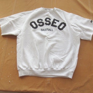 May include: A grey short-sleeved sweatshirt with the word "OSSEO" in black block letters and the word "BASEBALL" in smaller black letters below it.