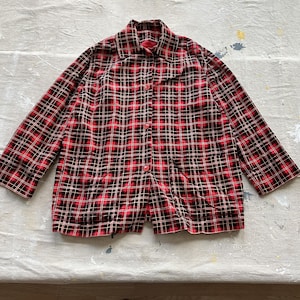 May include: A red and black plaid button-up shirt with long sleeves.