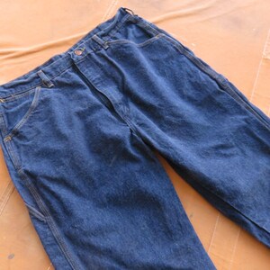 May include: A pair of dark blue denim work trousers with reinforced seams and pockets.