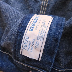 May include: A close-up of a blue denim jean label with the text "BIGBEN" and the size "36X30". The label also includes care instructions: "Machine wash with like colours, tumble dry, remove promptly, 100% cotton, Made in USA".