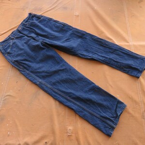 May include: A pair of dark blue denim jeans with a straight leg and a single seam down the outside of each leg.