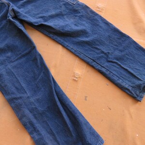 May include: A pair of blue denim jeans with a straight leg fit. The jeans have a light wash and are made of a soft, comfortable fabric.