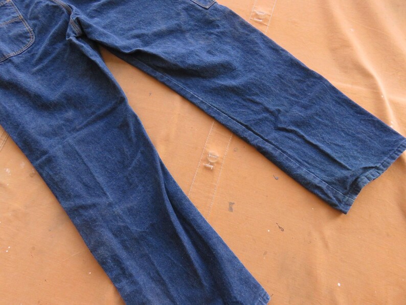 May include: A pair of blue denim jeans with a straight leg fit. The jeans have a light wash and are made of a soft, comfortable fabric.