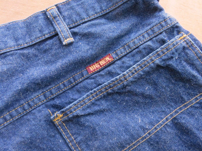 May include: Blue denim jeans with a back pocket and a red label that says "BIG BEN".