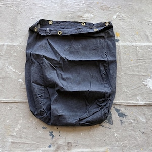 May include: A dark blue canvas drawstring bag with a gathered top and metal eyelets.