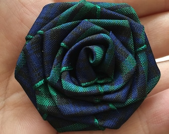 May include: A green and blue plaid fabric rose.