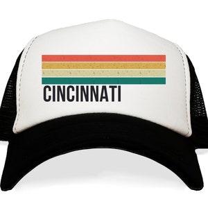 May include: A white and black trucker hat with a vintage-style rainbow stripe and the word "CINCINNATI" in black text.