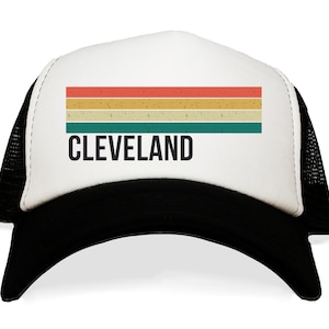 May include: A white and black trucker hat with a retro-style rainbow stripe and the word "CLEVELAND" in black text.