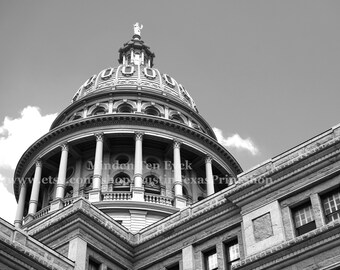 May include: Black and white photograph of a domed building with columns and architectural details. The image captures a low-angle view of the building against a cloudy sky. The text "Minden Ten Eyck" and website address are visible.