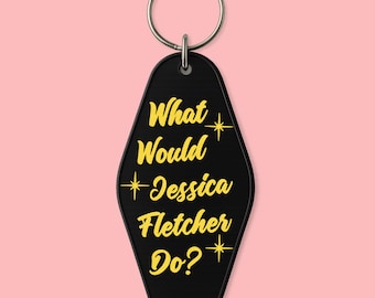 May include: Black motel-style keychain with the text "What Would Jessica Fletcher Do?" in yellow. The keychain has a silver ring at the top and a black, textured surface. The text is stylized with starburst accents.