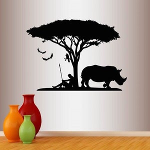 May include: Black and white silhouette wall decal featuring a rhino, a person sitting under a tree, and bats flying in the air. The decal is ideal for adding a touch of nature to any room.