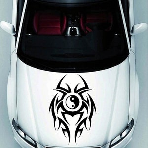 Puede incluir: Un coche blanco con un diseño tribal negro que presenta un símbolo yin yang en el capó.