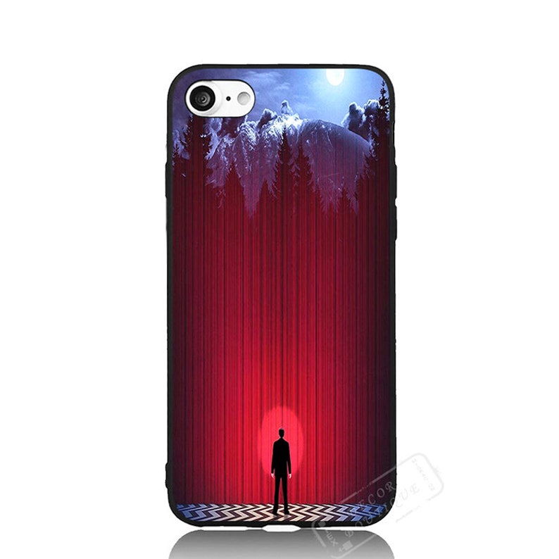 May include: A black phone case featuring a red and blue image of a silhouette of a person standing in front of a red curtain with a mountain scene in the background.