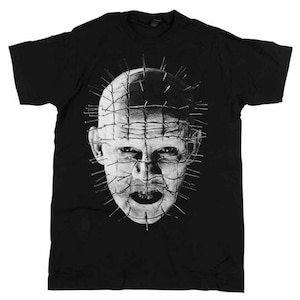 May include: Black t-shirt with a white graphic of a character from the horror movie Hellraiser. The character has a face covered in nails and a menacing expression.