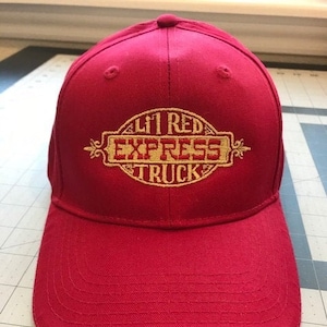 May include: Red baseball cap with a gold embroidered logo that says "Lil Red Express Truck".