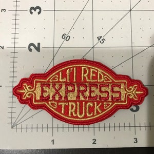 May include: Red and gold embroidered patch with the text "Lil' Red Express Truck".