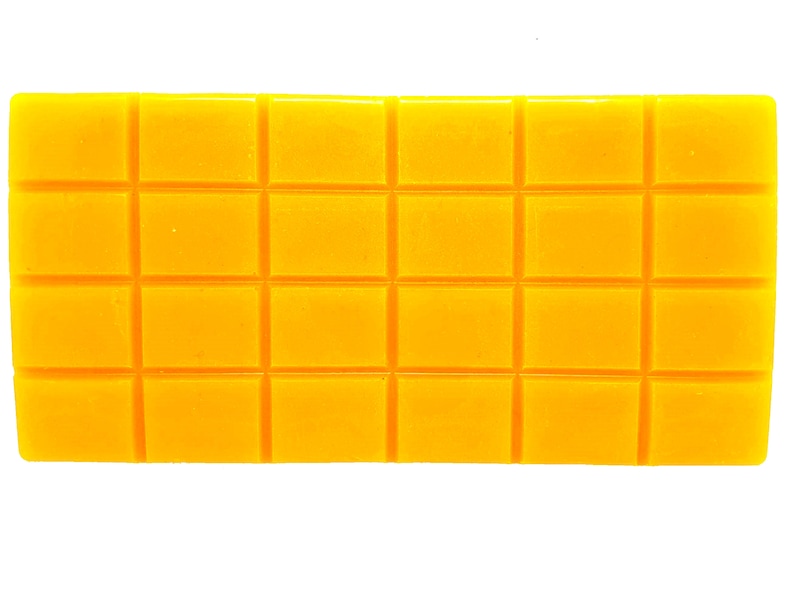 Pu&ograve; includere: Un blocco di cera giallo con un motivo a griglia, diviso in 18 quadrati.