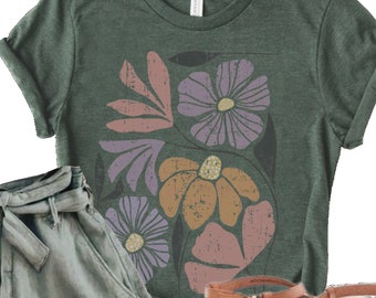 May include: A green t-shirt with a floral print featuring pink, purple, and orange flowers. The shirt is paired with green cargo shorts and brown sandals.