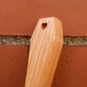 Puede incluir: Una cuchara de madera con un corte en forma de coraz&oacute;n en el extremo del mango.