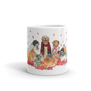 May include: White ceramic mug with a watercolour illustration of various dogs in autumnal outfits, including hats and scarves, set amongst pumpkins and falling leaves. A charming seasonal design.