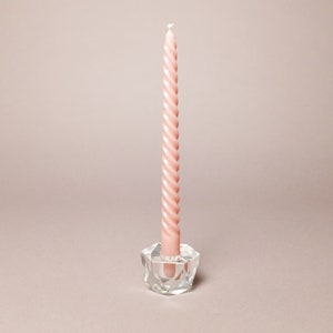 May include: A single, twisted, light pink candle in a clear glass candle holder with a faceted design.