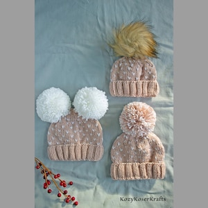 May include: Three knitted hats with pom-poms. Two hats have white pom-poms and one has a pink pom-pom. All hats have a light pink color with white polka dots.
