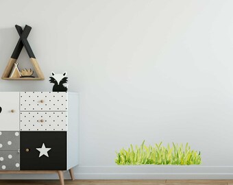 Può includere: Una cassettiera bianca con pois neri e un cassetto nero con una stella bianca. Una statuetta di volpe bianca e nera è posizionata sopra la cassettiera. Un adesivo di erba verde è sul muro bianco.