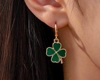 Peut inclure: Boucles d'oreilles dorées avec un pendentif trèfle à quatre feuilles vert.