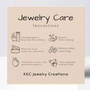 May include: A beige card with black text and illustrations outlining jewelry care instructions. The text reads "Jewelry Care Instructions" and includes tips like "Avoid getting wet, keep away from moisture", "Remove before sleeping", "Remove when exercising", "Avoid direct contact with perfume & cosmetics", and "Clean and polish with soft cloth". The card is signed "KKC Jewelry Creations".