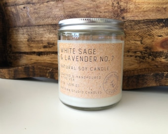 May include: A glass jar candle with a silver lid, labeled "White Sage & Lavender No. 7 Natural Soy Candle." The label is tan with black text and a circular logo. The candle is 8 oz (226 g) and crafted in the USA.