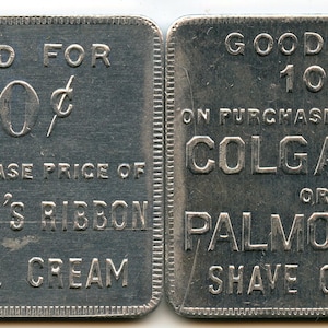 May include: Two vintage metal tokens, each with the text "GOOD FOR 10¢". One token reads "ON PURCHASE PRICE OF COLGATE'S RIBBON DENTAL CREAM". The other reads "ON PURCHASE PRICE OF COLGATE'S OR PALMOLIVE SHAVE CREAM".