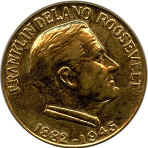 May include: A circular gold-coloured commemorative coin featuring a profile portrait of Franklin Delano Roosevelt facing right. The text FRANKLIN DELANO ROOSEVELT is arched along the top edge, and the years 1882-1945 are inscribed at the bottom.