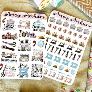 May include: Two sheets of stickers with a sewing theme. The first sheet has stickers with phrases like "Sew Crafty", "Sew Your Stress Away", and "Fabric Addict". The second sheet has stickers with sewing machines, spools of thread, and scissors.