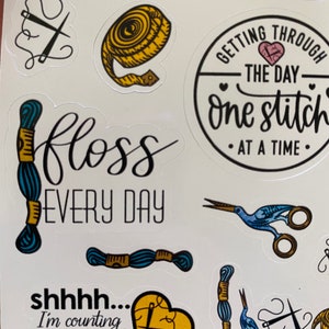 May include: A set of colorful stickers with embroidery and sewing themed designs. The stickers feature phrases like "Getting through the day one stitch at a time" and "Floss every day".