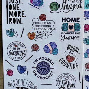 Peut inclure: Une feuille d'autocollants color&eacute;s avec diff&eacute;rents motifs et dictons li&eacute;s au crochet. Les autocollants pr&eacute;sentent des pelotes de laine, des crochets &agrave; crochet et des phrases comme "Juste une rang&eacute;e de plus", "Temps de se d&eacute;tendre" et "Le crochet est mon cardio".