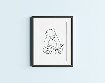May include: A black and white line drawing of a bear sitting and reading a book. The drawing is framed in a black frame.