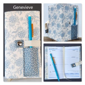 Op de afbeelding: Een stoffen plannerhoes met een blauw-wit bloemenpatroon, een bijpassend zakje, een elastische band met een zilveren metalen drukknoop en een blauwe pen. De binnenkant toont een weekkalenderpagina voor september 2027 met blauwe lijnen.