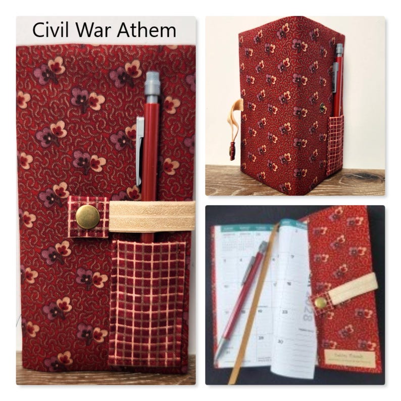 Op de afbeelding: Een stoffen plannerhoes met een rood bloemenpatroon, een bijpassend rood ruitjesvak, een beige elastische band met een koperen drukknoop en een rood vulpotlood. De tekst Civil War Athem staat bovenaan de afbeelding gedrukt.