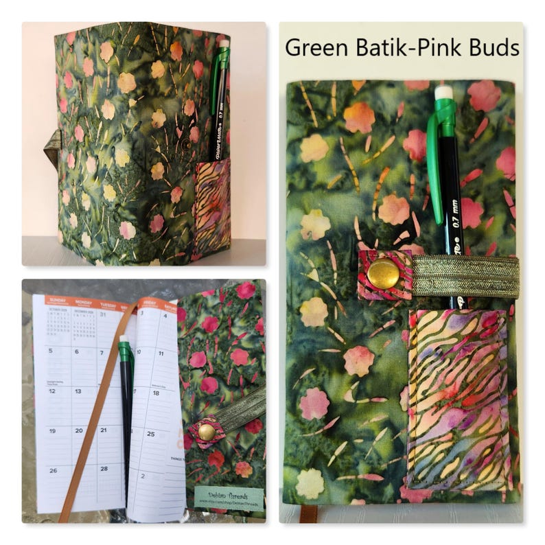 Op de afbeelding: Een stoffen plannerhoes met een groen batikpatroon met roze knoppen, een klein zakje met een veelkleurige zebra-achtige print, een elastische band met een messingkleurige drukknoop en een zwart vulpotlood. De tekst luidt Green Batik-Pink Buds.