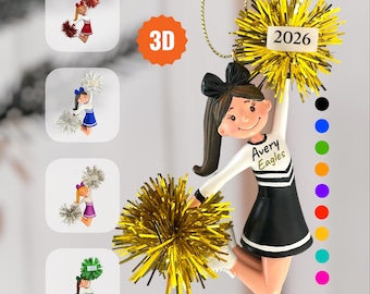 May include: A 3D cheerleader ornament featuring a figure in a black and white uniform with the text Avery Eagles, holding gold pom-poms and a 2026 tag. Four smaller circular inset images show variations in red, blue, purple, and green.