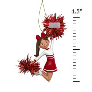 May include: A red and white cheerleader ornament with pom-poms. The ornament is 4.5 inches tall.